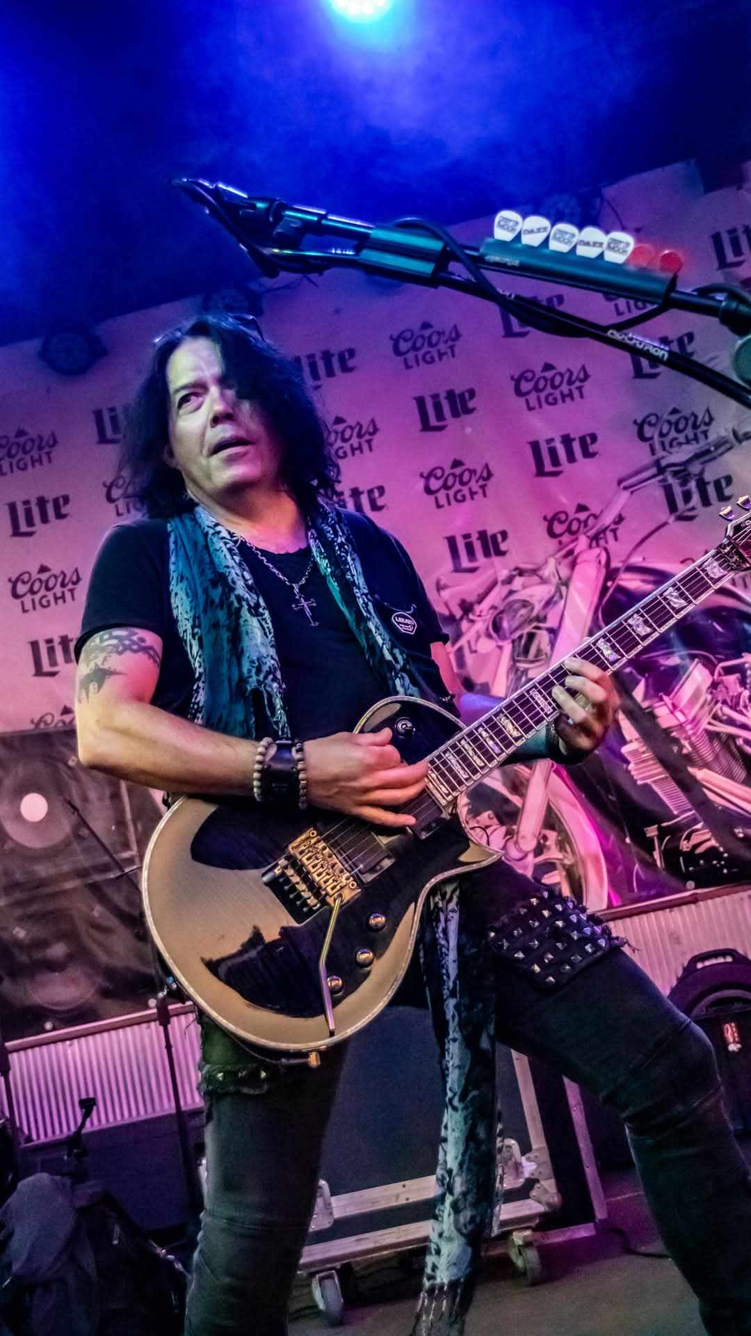 Guitarist with Les Paul on stage in pink and purple light