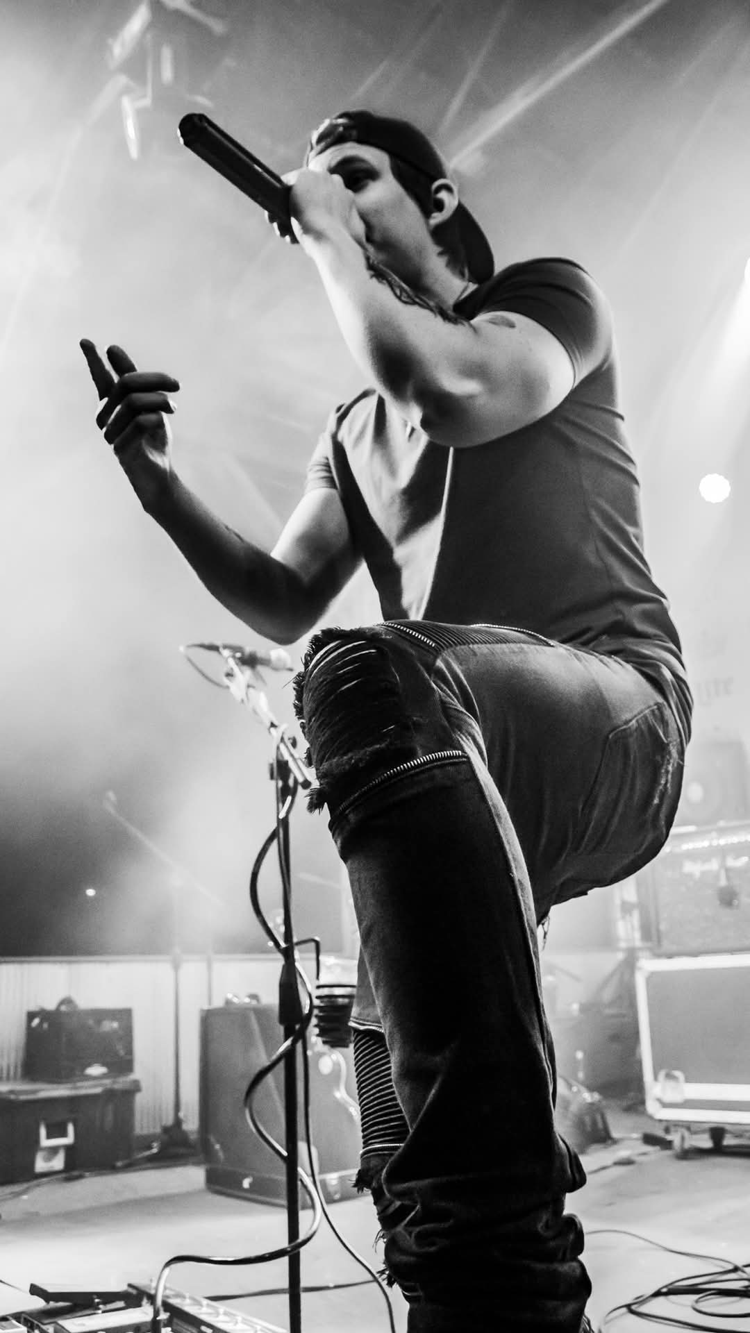 Vocalist with knee up on monitor — black and white