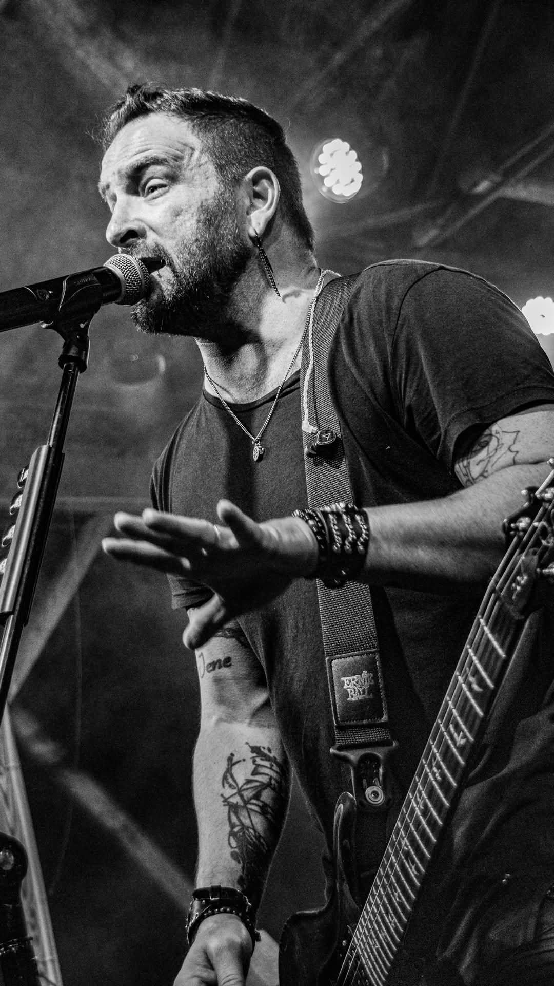 Vocalist mid-line at the microphone — black and white close-up