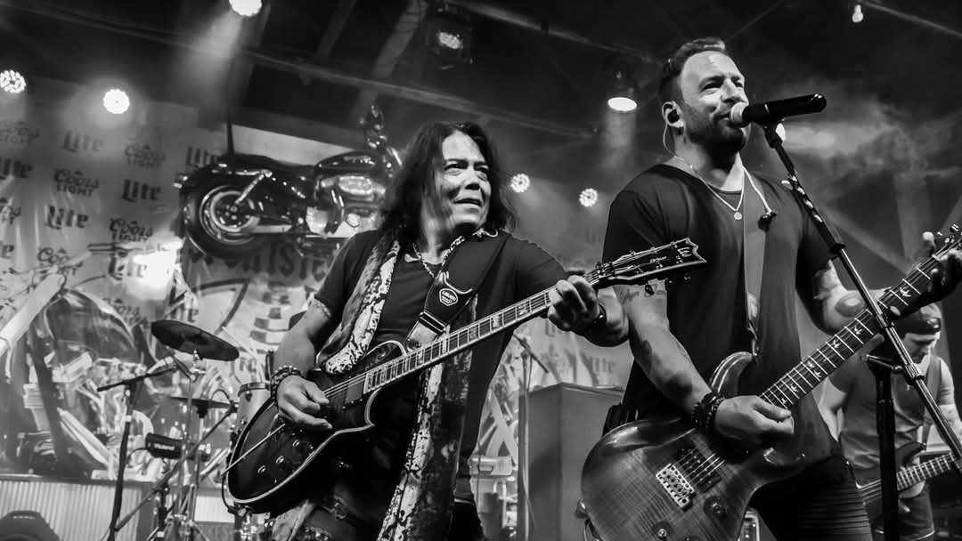 Lead guitarist and vocalist sharing the mic — black and white