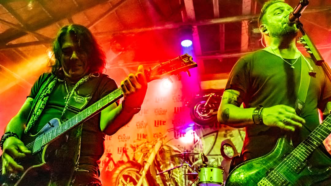 Two guitarists trading licks under red and green lights